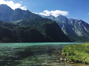 Scenic view of lake by mountains against sky