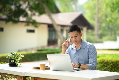 Businesswoman using laptop while sitting on table