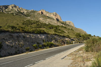 Road by mountain against clear sky