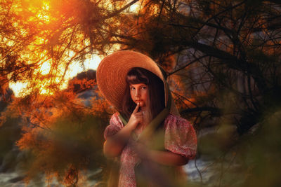 Portrait of young woman standing in park during autumn