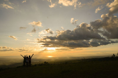 People on field against sky during sunset