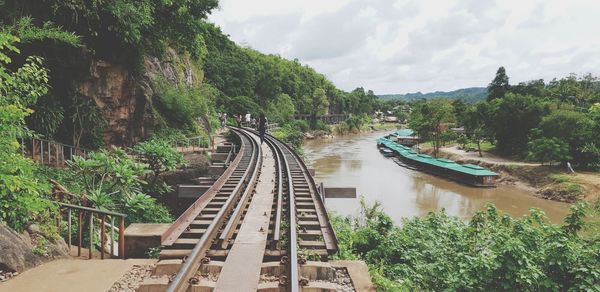 Railroad tracks by bridge against sky