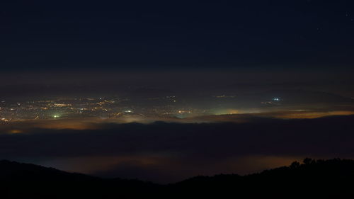 Scenic view of silhouette mountain against sky at night