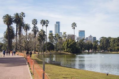 Scenic view of river and trees in city against sky