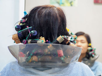 Rear view of woman with hair curlers