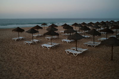 Early morning in blue hour before sunrise beach umbrellas and sunbeds. salema, algarve, portugal