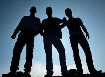 Rear view of men standing against clear sky