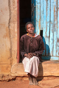 Portrait of woman sitting on doorway