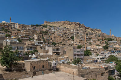 Buildings in city against clear blue sky