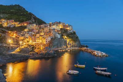 Italy, la spezia, manarola, view of coastal village in cinque terre at dusk