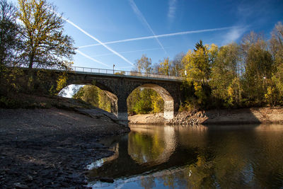 Arch bridge over river against sky