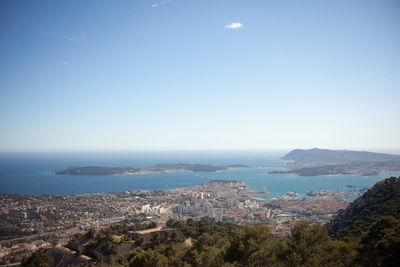 Aerial view of townscape by sea against sky