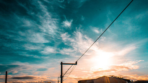 Low angle view of silhouette electricity pylon against sky