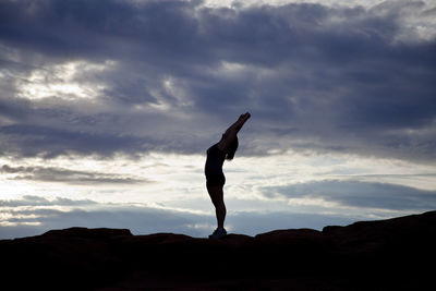 Silhouette of woman against cloudy sky