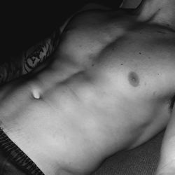 Midsection of shirtless man lying down