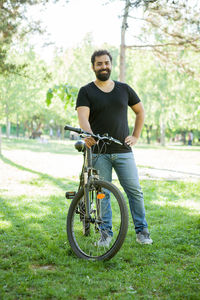 Young man riding bicycle on field