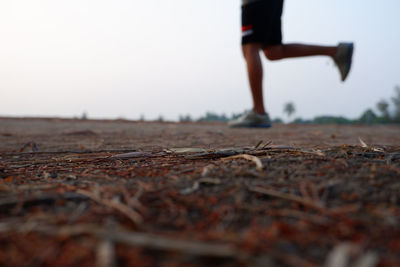 Low section of man running on land