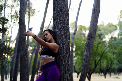 Woman with braids taking a selfie with her smartphone