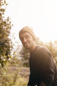 Portrait of young man standing against sky