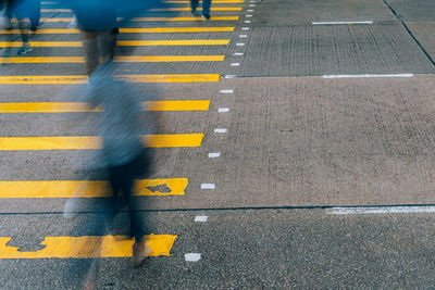 Low section of man walking on road