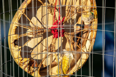 Close-up of decoration seen through chainlink fence