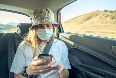 Portrait of man using mobile phone while sitting in car