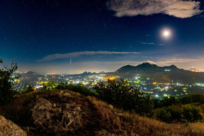 Illuminated cityscape against sky at night