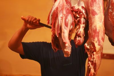 Man cutting meat in butcher shop