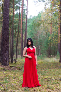 Portrait of young woman standing at forest