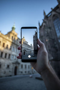 Midsection of person photographing with mobile phone