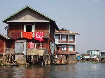 Houses by building against clear sky