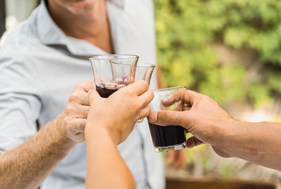 Midsection of man drinking glass