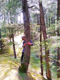 Full length of woman amidst trees in forest