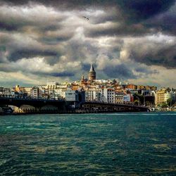 River in city against cloudy sky