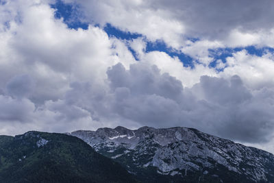 Low angle view of snowcapped mountains against sky