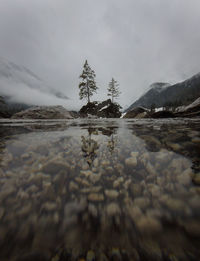 Surface level of lake against sky during winter