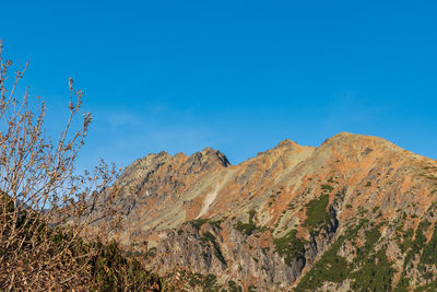 Low angle view of mountain against blue sky