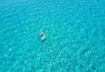 High angle view of couple swimming in sea