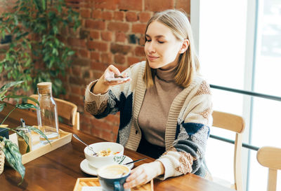 Woman sitting on table at cafe