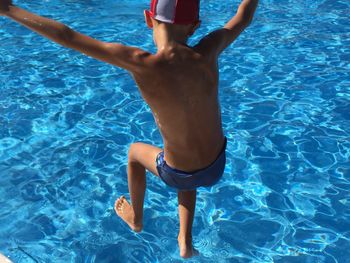 Low section of little boy swimming in pool