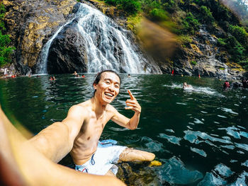 Full length of shirtless man standing on rock