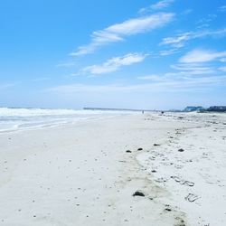 Scenic view of beach against blue sky