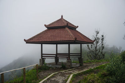 House on field by building against sky