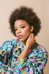 Portrait of young woman looking away against wall