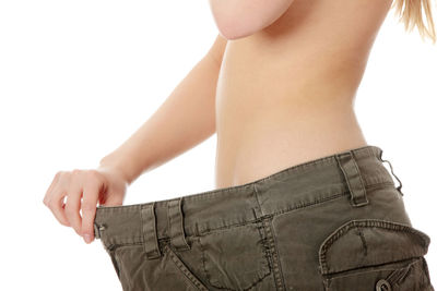 Midsection of woman standing against white background