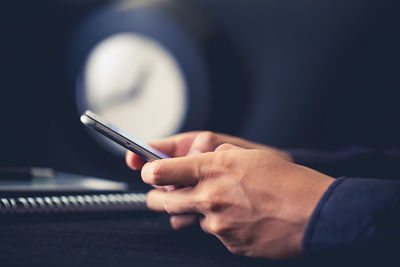 Cropped hands of woman using mobile phone