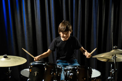 Young man playing drum on stage