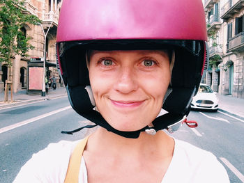 Close-up portrait of smiling young woman wearing helmet