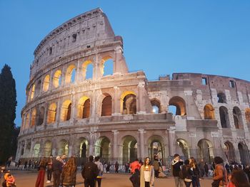 Group of people in front of historical building against sky