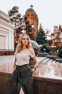 Portrait of woman standing against building